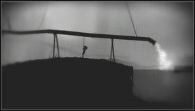 Najpierw zeskakujemy do rowu i przesuwamy kawałek drewna mniej więcej na środek [1] (wydostaniemy się stąd wskakując na ściankę po lewej), a potem łapiemy za łańcuch przymocowany do rynny i trzymamy go dopóki dół nie napełni się wodą [2] - Rozdział 16 | Opis przejścia Limbo - Limbo - poradnik do gry