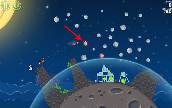Pierwsze rozwiązanie polega na zepchnięciu zaznaczonej asteroidy detonując ptaka w mniej więcej zaznaczonym miejscu, aby kamyk mógł po drodze natrafić na drugą asteroidę tym samym zwiększając szanse na zniszczenie wszystkiego - Level 1 - 18 | Pig Bang | Angry Birds Space - Angry Birds Space - poradnik do gry