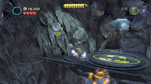 Batmanem przejdź na platformę z prawej i kiedy Superman zniszczy maszynę zasilającą, podejdź bohaterem do kabla (obrazek) i zjedź nim na centralną platformę - Nieproszeni goście | Opis przejścia LEGO Batman 2 DC Super Heroes - LEGO Batman 2: DC Super Heroes - poradnik do gry