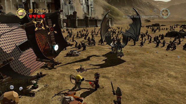 Podczas walki z Nazgulem dosiadającym bestii musimy trafić w kilka tarcz znajdujących się wysoko po lewej stronie areny - Bitwa na polach Pelennoru | Znajdźki | LEGO The Lord of the Rings - LEGO The Lord of the Rings: Władca Pierścieni - poradnik do gry