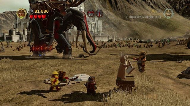 Na lewo od statuy zapisu gry znajduje się popękany klocek LEGO - Bitwa na polach Pelennoru | Znajdźki | LEGO The Lord of the Rings - LEGO The Lord of the Rings: Władca Pierścieni - poradnik do gry