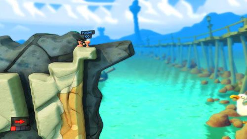 Przy pomocy Mobilizatora pozbywamy sie przeciwnika na wzniesieniu [ilustracja], po czym zeskakujemy na dół korzystając ze Spadochronu - Plaża | Łamigłówki | Worms Revolution - Worms: Revolution - poradnik do gry