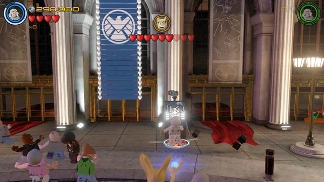 Podczas walki z Lokim, podejdź do widocznego na obrazku budynku, przy którym znajduje się komputer - Postacie | Kino plenerowe - sekrety | LEGO Marvels Avengers - LEGO Marvels Avengers - poradnik do gry