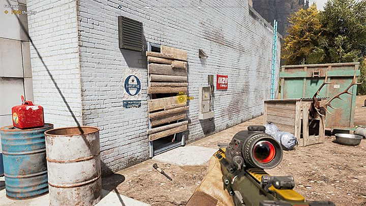 Obejdź budynek dookoła i odszukaj pokazane na obrazku przejście, które zabito deskami - Lokacje kultu i skrytki prepperskie na Rzece Henbane | Rzeka Henbane | Far Cry 5 - Far Cry 5 - poradnik do gry