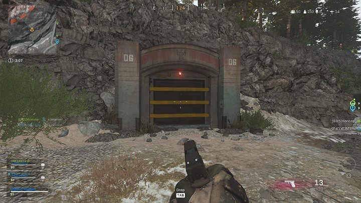 Na powyższym obrazku można zauważyć gracza, który stoi przed jednym z bunkrów - Warzone: Bunkry - lokacje, nagrody, jak otworzyć? - Call of Duty Warzone - poradnik do gry