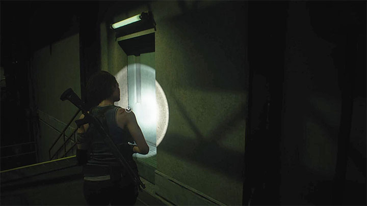 Po powrocie w okolice schodów zainteresuj się pokazanymi na obrazku zielonymi drzwiami - Resident Evil 3: Zagadka z odnalezieniem bezpieczników w magazynie - Resident Evil 3 - poradnik do gry