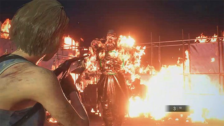 Po tym jak zbiornik paliwa zostanie zniszczony awansujesz do drugiej fazy walki - musisz atakować i jednocześnie unikać ataków chodzącego płonącego Nemesisa - Resident Evil 3: Miejsce rozbiórki solucja, opis przejścia - Resident Evil 3 - poradnik do gry