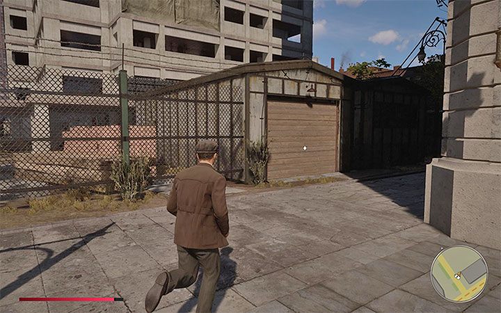 Obejdź plac budowy dookoła aż znajdziesz pokazany na obrazku garaż z sekretnym pojazdem - Mafia Definitive Edition: Fleme Spearr - ukryty samochód, gdzie znaleźć - Mafia 1 Definitive Edition - poradnik, solucja
