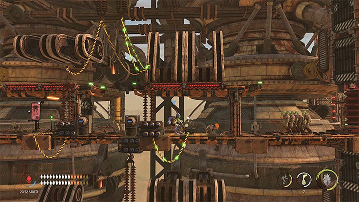 Kierujemy się w lewo, unikając zmiażdżenia przez kolejne półki i zatrzymując się z Mudokonami dokładnie pomiędzy maszynami - Oddworld Soulstorm: Dotarcie na szczyt Fueling Tower, Phat Station - solucja - Oddworld Soulstorm - poradnik do gry