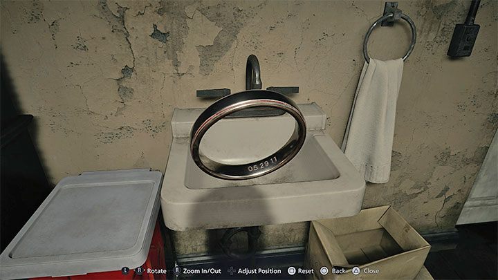 Wybierzcie pierscień z inwentarza żeby zbadać go z bliska (Examine) - Resident Evil Village: House Beneviento, Zagadka z lalką kobiety - rozwiązanie - Resident Evil Village - poradnik do gry