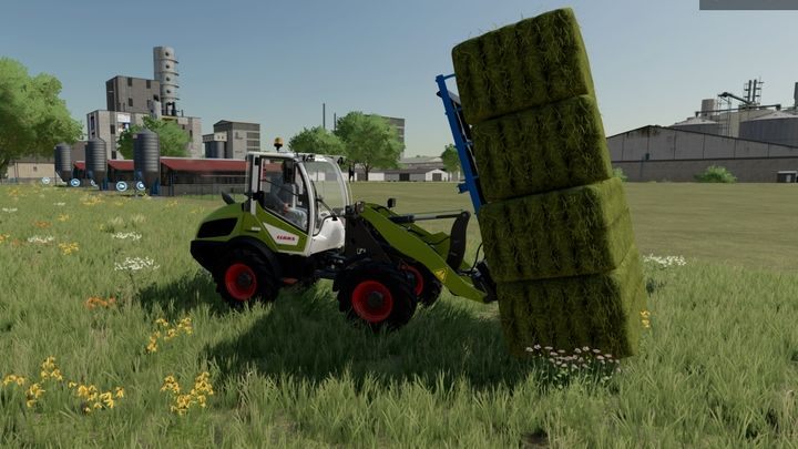 Ładowacze czołowe posiadają specjalne wysokie widły, które dobrze radzą sobie z podnoszeniem i ładowaniem bel zebranych przez maszyny samozbierające - Farming Simulator 22: Belowanie - porady - Farming Simulator 22 - poradnik do gry