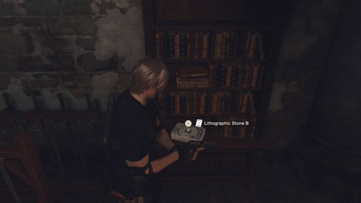 Lithographic Stone B leży obok półki z książkami - Resident Evil 4 Remake: Zagadka z Lithographic Stones z Bindery (rozdział 8) - Resident Evil 4 Remake - poradnik do gry