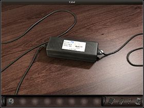 Teraz agentka ogląda leżący pośrodku blatu zasilacz (zbliżenie) - Hotel #1 | Francja, Paryż | Art of Murder Klątwa Lalkarza - Art of Murder: Klątwa Lalkarza - poradnik do gry